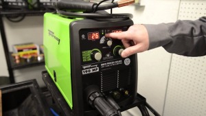 A hand pressing a button on the machine