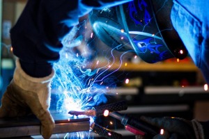 man working wearing a welding helmet