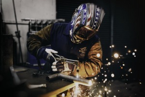 Welder leaning on the table doing work